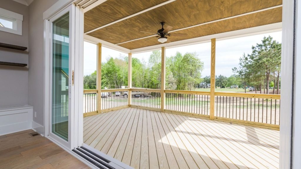 New outdoor living space crafted with premium decks services, including wood flooring and covered roof.
